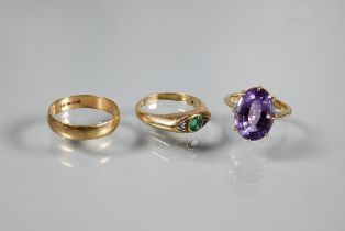 Three rings - a 9ct yellow gold set with circular emerald with diamond either side in rubover