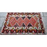 An antique Kazak pale red ground rug, the lozenge pole design within geometric borders, 206 cm x 130