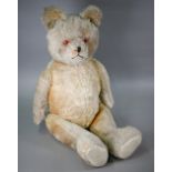 A large vintage mohair teddy bear with glass eyes and stitched nose, swivelling head and limbs, 80