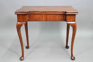 A Georgian walnut folding tea table, raised on a single gateleg, on slender cabriole legs to pad