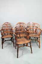 A well matched harlequin set of seven yew and elm seat low splat back Windsor armchairs, 19th