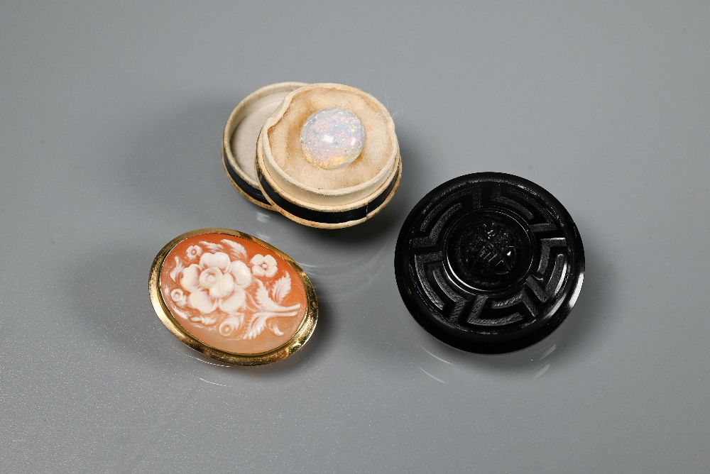 A Victorian jet mourning brooch, an oval cameo brooch featuring floral spray and a loose opal (3)