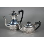 A late Victorian silver tea pot and coffee pot with composite handles and ebonised finials, James