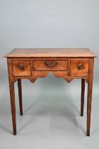 An 18th century oak three drawer side table raised on square section legs