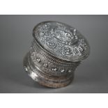 An Indian low-grade silver cylindrical box and cover, embossed and chased with animals and