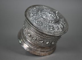 An Indian low-grade silver cylindrical box and cover, embossed and chased with animals and