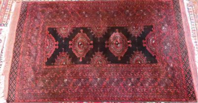 An old Belouch rug, the brown-red ground with stylised lozenge guls, 214 cm x 140 cm