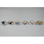 Five various rings, three set blue topaz, one channel set with coloured sapphires, one dark blue