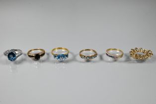 Five various rings, three set blue topaz, one channel set with coloured sapphires, one dark blue