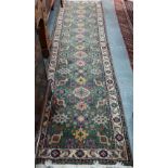 An old Persian green ground runner, 292 cm x 76 cm