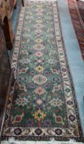 An old Persian green ground runner, 292 cm x 76 cm