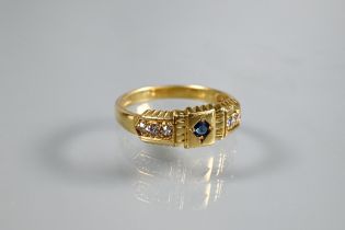 An antique 18ct yellow gold ring set with blue sapphire to centre, with three diamonds to each