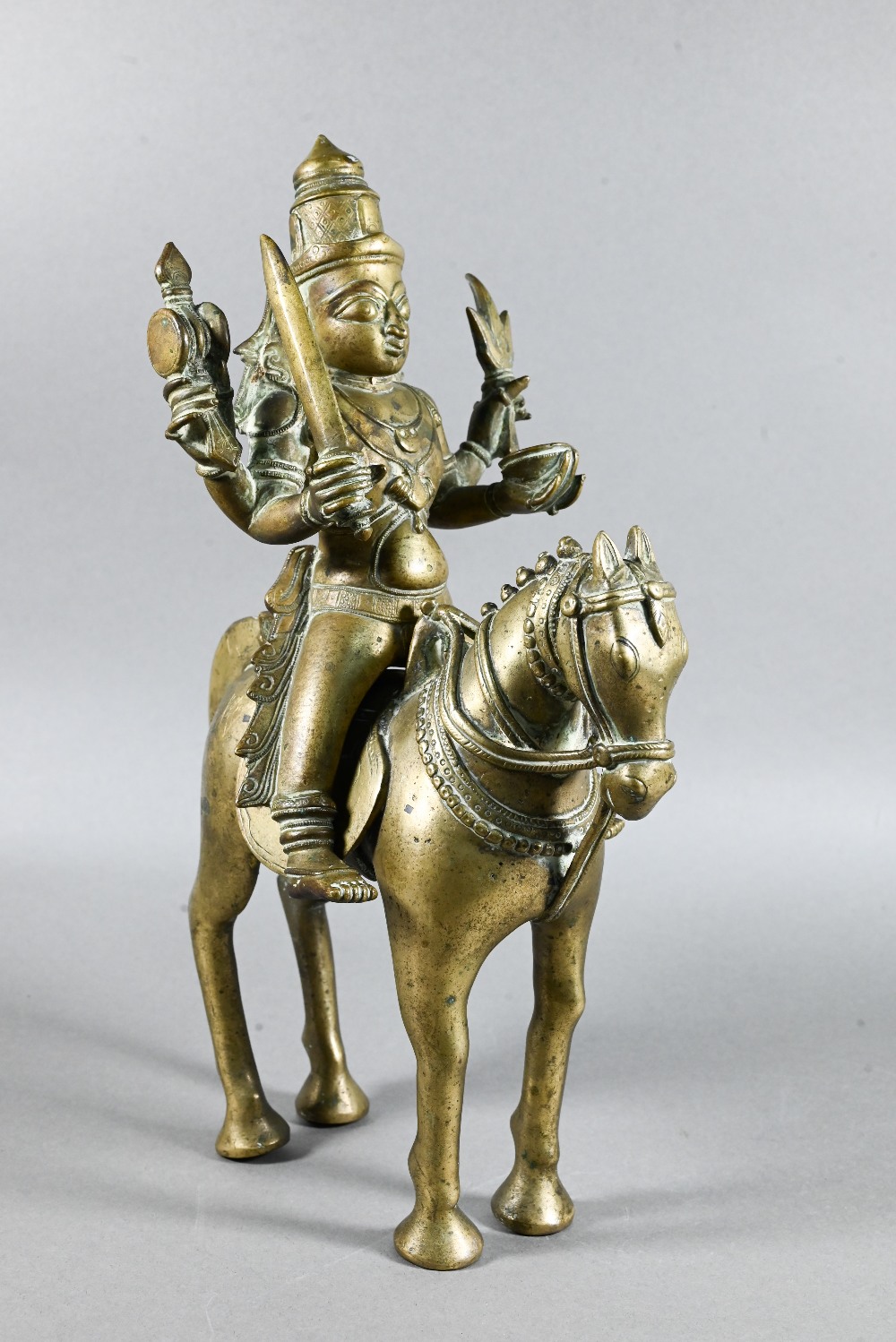 An Indian brass figure of Khandoba (manifestation of Shiva) on the back of his horse, the four-armed