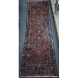 An old Persian Sarouk runner, the stylised floral vine design on pale red ground, 358 cm x 107 cm