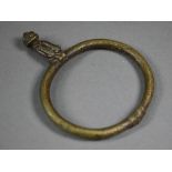 A West African bronze bangle, surmounted by a seated man, 11.5 x 9 cm