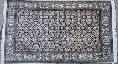 An old silk Hereke rug, the field of repeating geometric flower heads on dark blue ground, 157 cm