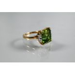 A ring, the square cut green tourmaline with two diamonds to each shoulder, yellow and white metal