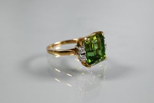 A ring, the square cut green tourmaline with two diamonds to each shoulder, yellow and white metal