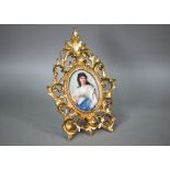 A German porcelain oval plaque painted with Medea after Sichel, 12 x 9 cm, in ornate giltwood