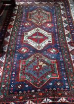 An old Caucasian kelleh carpet, the blue ground with multi-coloured lozenge design, 326 cm x 178 cm