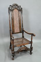 A William & Mary oak framed cane panelled armchair, with moulded frame, scroll arm ends and front