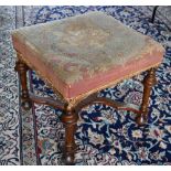 A Queen Anne style walnut framed stool, 19th century, with distressed overstuffed needlepoint