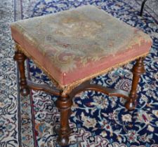 A Queen Anne style walnut framed stool, 19th century, with distressed overstuffed needlepoint