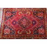 A contemporary South West Persian Shiraz rug, the traditional blue ground centred by a red
