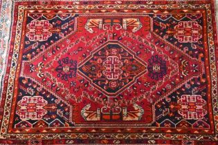 A contemporary South West Persian Shiraz rug, the traditional blue ground centred by a red