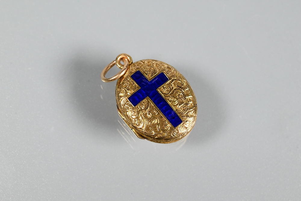 An oval engraved locket with blue enamelled cross to front, unmarked yellow metal, approx 2.9g,