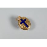 An oval engraved locket with blue enamelled cross to front, unmarked yellow metal, approx 2.9g,
