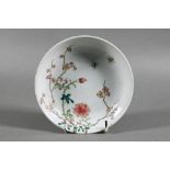 A Chinese famille rose dish painted in polychrome enamels with two insects, blossoming peony and