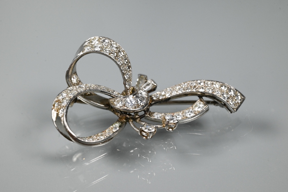 A diamond brooch, the white metal set overall with mixed cut diamonds in the style of a loosely-tied - Image 2 of 3