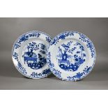 A pair of 18th century Chinese blue and white plates, painted with a vase of flowers on a table in a