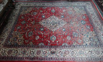 An old Persian mahal carpet, the pale red ground centred by a stylised floral medallion, 377 cm x