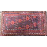 An antique Belouch rug, the red-brown ground with narrow blue bands and wide kelim ends, 202 cm x