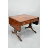 A good Regency rosewood cross-banded mahogany sofa table, the rounded drop leaves over two frieze