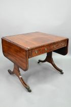 A good Regency rosewood cross-banded mahogany sofa table, the rounded drop leaves over two frieze