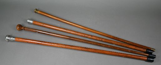 Two antique Chinese malacca walking canes with embossed and chased silver pommels, to/w two wooden