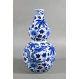 A 19th/20th century Chinese blue and white double gourd vase painted with two sinuous dragons
