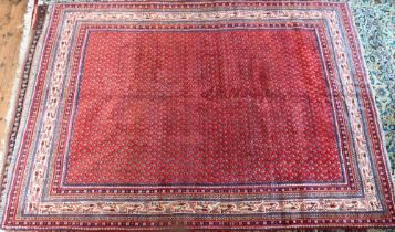 A Persian Arak carpet, the red ground with repeat all-over design of stylised boteh, 294 cm x 218 cm