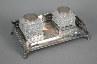 A silver inkstand with pierced gallery and paw feet, fitted with two silver-topped square-cut