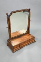 A George III cross-banded walnut toilet mirror, raised on a three drawer base on ogee moulded