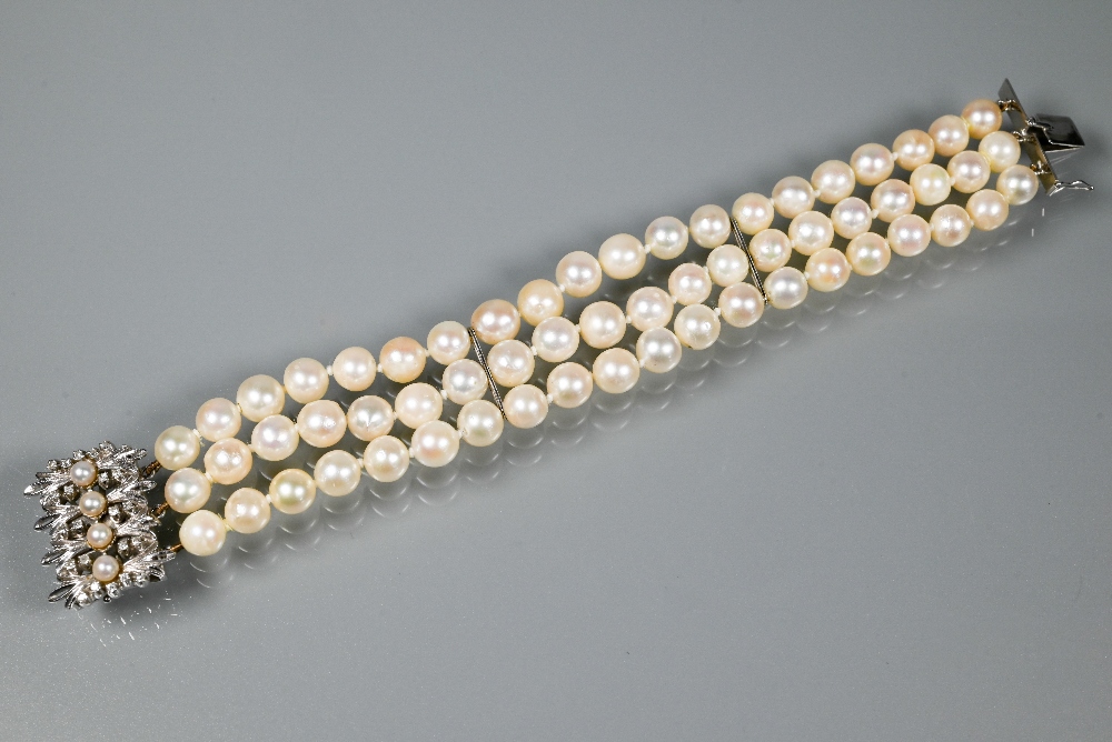 A pearl bracelet, the three-rows of cultured pearls knotted throughout onto fancy white metal set