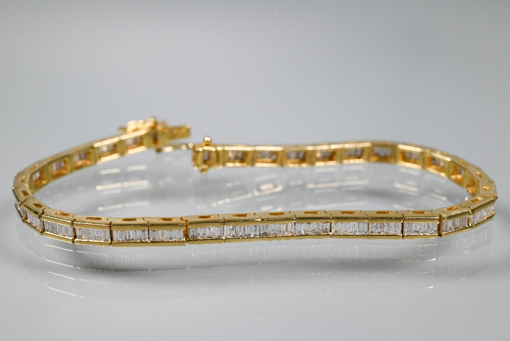 A modern diamond bracelet, the baguette-cut diamonds channel set in 18ct yellow gold, with concealed - Image 2 of 5