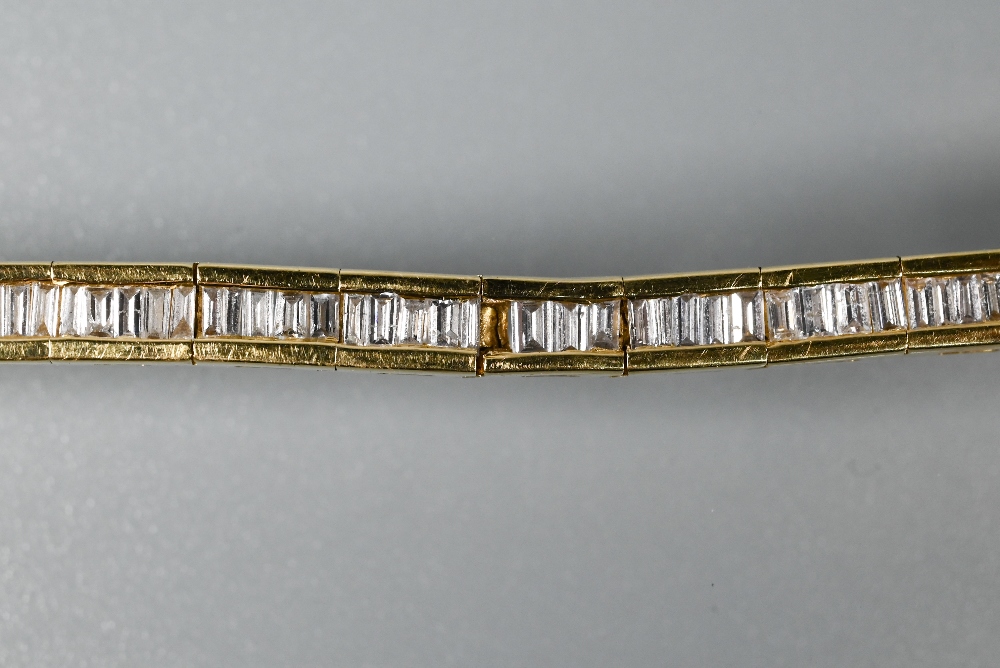 A modern diamond bracelet, the baguette-cut diamonds channel set in 18ct yellow gold, with concealed - Image 4 of 5