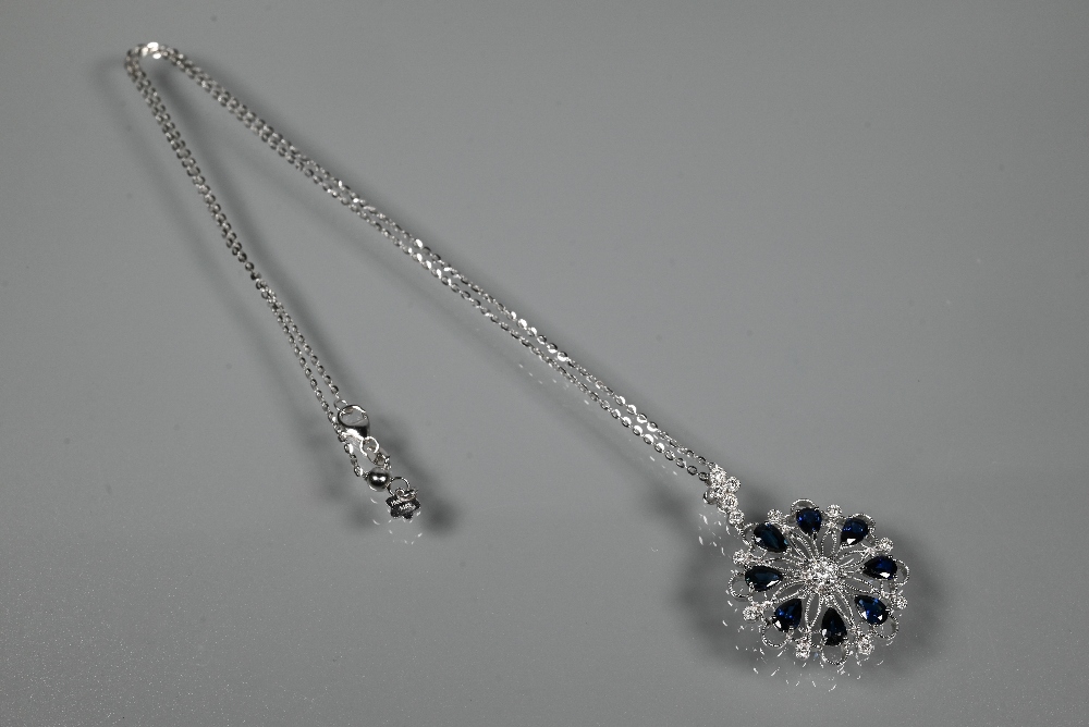 A sapphire and diamond pendant, the open circular millgrain wirework flower-style mount set with