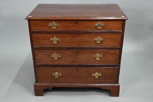 A George III mahogany chest of four long graduated drawers, later brass fittings, raised on shaped