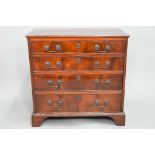 A George III mahogany chest of four long graduated drawers, with later cast brass fittings, raised