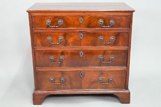 A George III mahogany chest of four long graduated drawers, with later cast brass fittings, raised